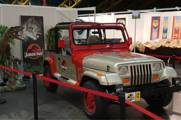 Jeep voiture de jurassic park. Avec un décor en fond de dinosaure
