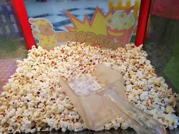 pop corn dans la machine avec sa cuillère pour verser dans les sachets